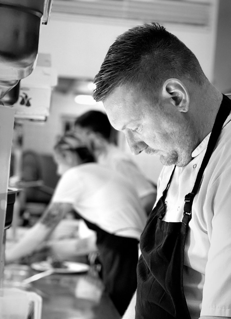 Food at Quex Weddings & Events - image displays head chef, cooking a meal.